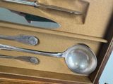 someone is holding a knife, spoon, and spoon rest in a box