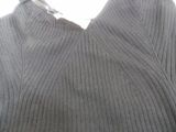 the sweater is gray and has a white tag on it