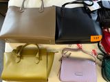 many different purses on a table in a room