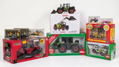 quatre modèles différents de tracteurs dans des boîtes, posés sur une surface blanche