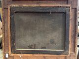 an old picture frame sitting on top of a table in a room