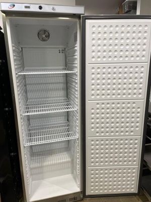 un réfrigérateur vide, la porte ouverte, dans une pièce