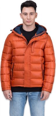 un homme vêtu d'une veste orange et d'un jean, debout devant un fond blanc