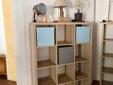 two bookshelves in the corner of a room with a lamp on top of them