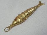 un objet en forme de poisson rouge orné d'une pierre rouge