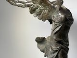 statue of a woman with wings on her head and a bird on her arm