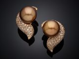 a pair of brown pearls and diamonds on a black surface