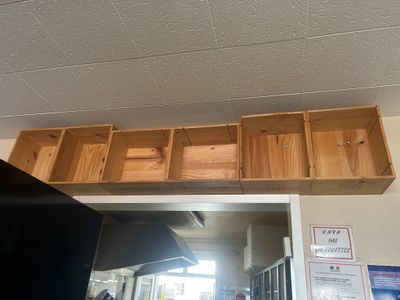 a wooden shelf above a television in a room