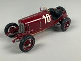 a red model of a racing car on a white surface