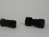 two pieces of black plastic that are on a white surface