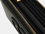 the inside of a black purse with gold zippers on a white background