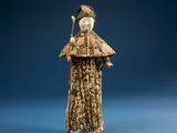 figurine of a woman in a fur coat with a bird on her shoulder
