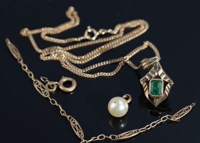 a necklace and a pearl on a black surface