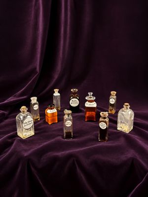 plusieurs petites bouteilles d'alcool posées sur un tissu violet