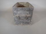 a small metal box with a handle on a table