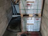une pile de cartons posée sur une palette dans un garage