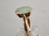 an image of a gold ring with a green stone in it