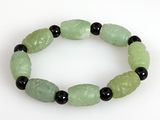 un bracelet vert orné de perles noires sur un fond blanc