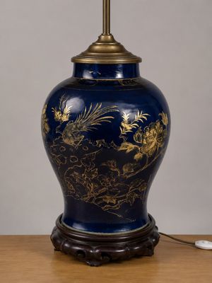 un vase bleu orné d'un dragon doré, posé sur une table