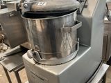 un grand mixeur posé sur un support métallique dans une cuisine