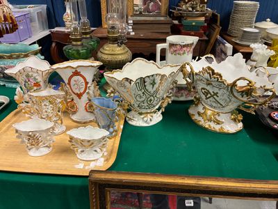 une table verte sur laquelle sont disposés de nombreux vases anciens