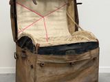 une vieille valise posée par terre dans une pièce