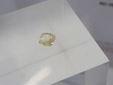 a close up of a piece of yellow diamond on display in a glass case