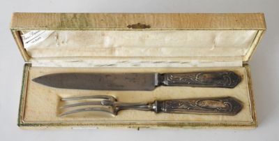 two knives and a fork in a box on a table