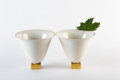 deux vases blancs contenant chacun une feuille verte