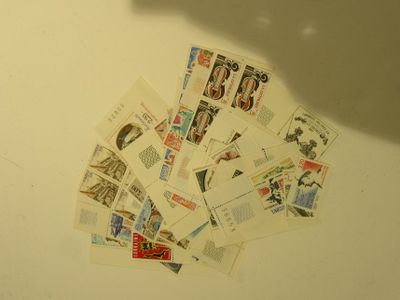 a pile of stamps sitting on a table next to a pair of scissors