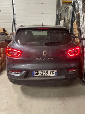 a car that is parked in a garage next to a fence
