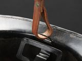 a leather handle on the handle of a black pot