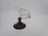a glass vase with a black base on a white surface