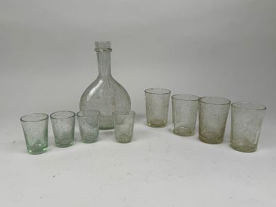 bottles and glasses are lined up on a white surface
