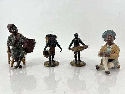 three figurines of people sitting on a white surface with a white background