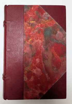 un gros plan sur un livre rouge à la couverture marbrée