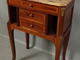 a small wooden table with a marble top on it
