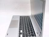 a silver laptop with a black keyboard on a white surface