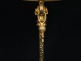 an antique brass table lamp with a white shade on a black background