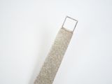 a silver tie that is laying on a white surface