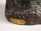 a bronze statue of a dog with a plaque on it