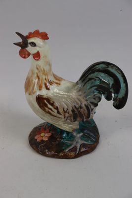une figurine représentant un coq sur fond blanc