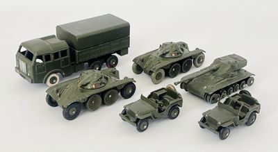 des véhicules militaires miniatures sont alignés en rang sur une surface blanche
