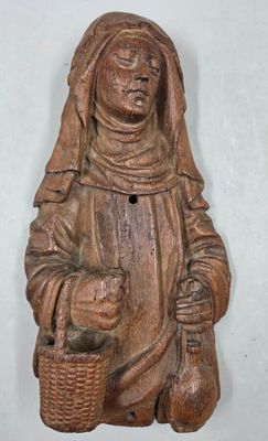a wooden statue of a woman holding a basket and a basket