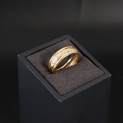 une bague en or dans un écrin noir posé sur une surface noire