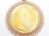 an image of a gold coin pendant with a woman ' s face on it