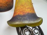 a vase that has a bell on it on a table