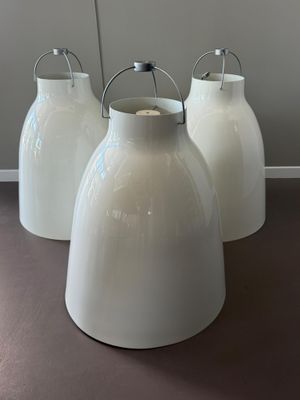 trois vases blancs posés sur une table dans une pièce