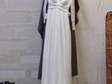 a white dress hanging on a clothes rack in a room