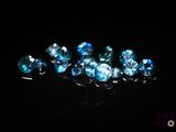 un gros plan sur un bouquet de diamants bleus posés sur une surface noire